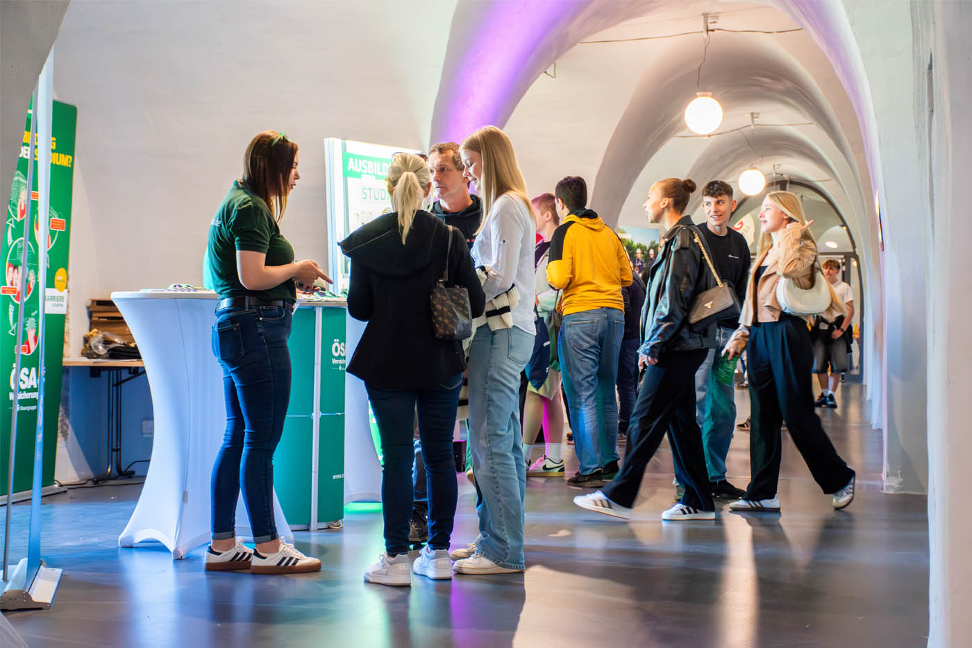 Menschen stehen in Gruppen in einem Gewölbegang
