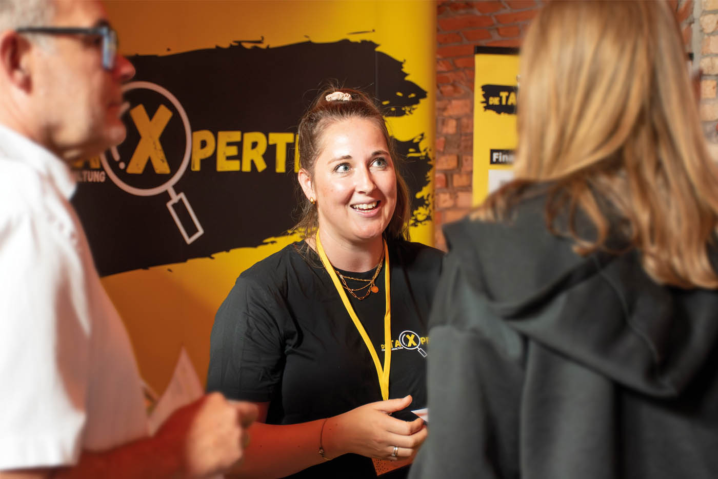 Frau lacht und unterhält sich am Messestand mit Frau